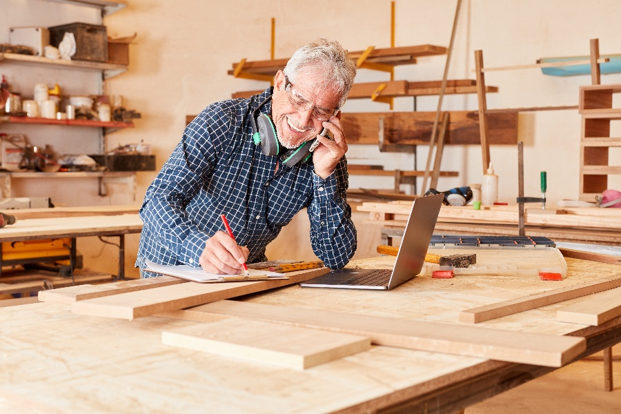 Small business owner smiling while working — gain web design helps businesses like his get more customers